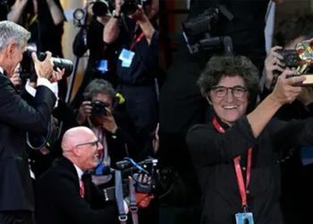 جورج كلوني يهدي جائزته إلى مصورة في مهرجان البندقية ويتابدل معها الأدوار